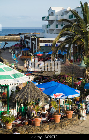 dh Promenade Cafés COSTA TEGUISE LANZAROTE Beach front Touristen in Cafés und zu Fuß entlang der promenade Stockfoto