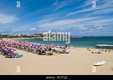 dh Playa de Las Cucharas COSTA TEGUISE LANZAROTE Menschen Sonnenbaden am Strand Sonnenschirme und Sonnenliegen Stockfoto