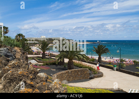 Dh Playa de las Cucharas COSTA TEGUISE LANZAROTE Touristische Paar entlang Palmen gesäumten Promenade Stockfoto