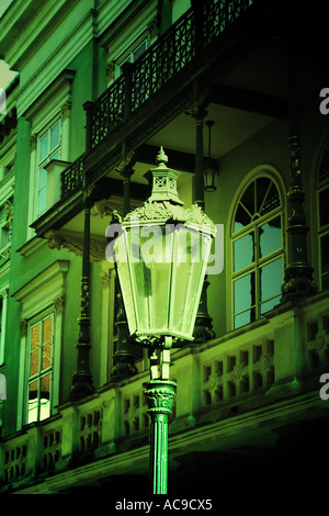 Alte Straßenlaterne vor einem kunstvollen Gebäude in der Nähe des Opernhauses in Prag, Tschechische Republik. Stockfoto