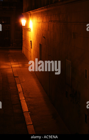 Dunkel beleuchtete Gasse in Prag bei Nacht, beleuchtet von einer einzigen Straßenlaterne, die Schatten auf die Wände wirft. Naprstkova Straße, Prag, Mala Strana bei Nacht. Stockfoto