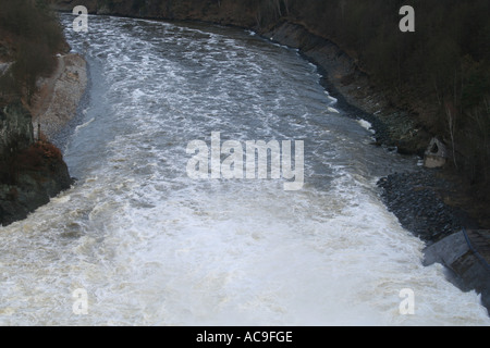 Ein mächtiger Staudamm, der Wasser in einen Fluss in der Tschechischen Republik abgibt. Eine atemberaubende Ausstellung von Ingenieurskunst inmitten einer natürlichen Waldlandschaft. Stockfoto