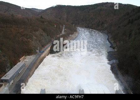 Ein mächtiger Staudamm, der Wasser in einen Fluss in der Tschechischen Republik abgibt. Eine atemberaubende Ausstellung von Ingenieurskunst inmitten einer natürlichen Waldlandschaft. Stockfoto