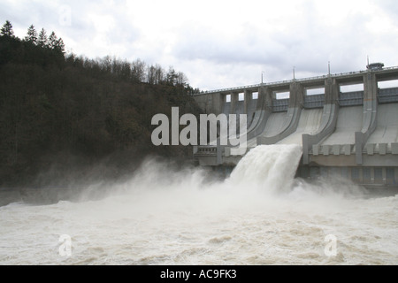 Ein mächtiger Staudamm, der Wasser in einen Fluss in der Tschechischen Republik abgibt. Eine atemberaubende Ausstellung von Ingenieurskunst inmitten einer natürlichen Waldlandschaft. Stockfoto