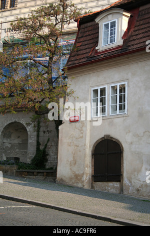 Nerudova Straße am frühen Morgen in Prag, mit einem malerischen Haus mit Bogentür und einem Baum im Hintergrund. Stockfoto