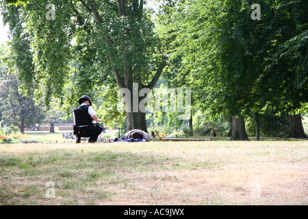 Polizisten im Gespräch mit einem betrunkenen Obdachlosen in St James' Park Stockfoto