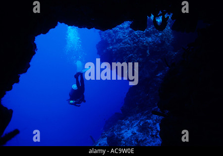 Taucher aus einer Höhle schwimmen. Stockfoto