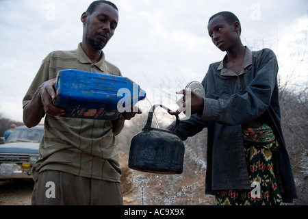 WESTERN SOMALIA 2. März 2006 Fahrer verleiht Wasser ein Nomade betteln um Wasser von der Seite der Straße Stockfoto