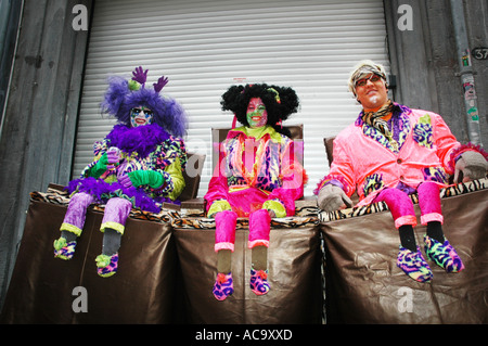 Drei Teilnehmer der Karneval im Hause gemachte Kostüme sitzen mit sehr kurzen Beinen als Parodie Akt Maastricht Niederlande Stockfoto