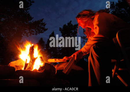 Frau Rechen ein Feuer Stockfoto