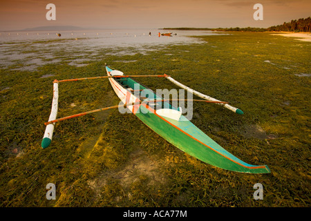 Fischerboat mit Ausleger an einem Strand, Philippinen Stockfoto