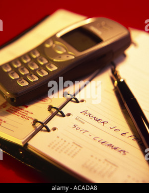 Handy-Stift auf ein Tagebuch auf rotem Grund Stockfoto