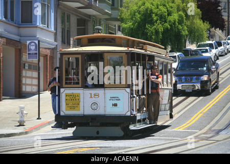 Seilbahn mit Touristen in den offenen Türen auf den steilen Straßen in den Hügeln von San Francisco, Kalifornien, USA Stockfoto