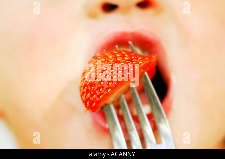 Kind eine Erdbeere essen Stockfoto