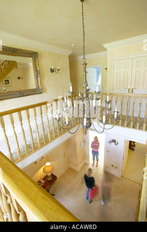 Treppen auf Balkon des großen modernen Haus mit Kronleuchter und Familie Stockfoto