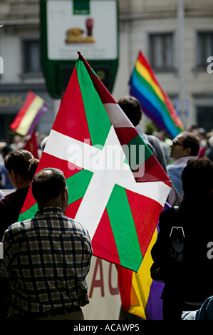 Baskische nationale Flagge die Ikurrina Hintergrundbeleuchtung während politische Demonstration im Zentrum von Bilbao Stockfoto