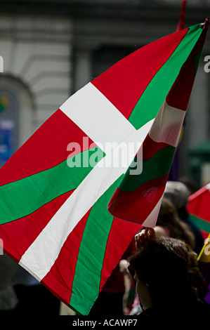 Baskische nationale Flagge die Ikurrina Hintergrundbeleuchtung während politische Demonstration im Zentrum von Bilbao Stockfoto
