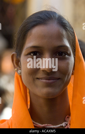 Porträt von einer attraktiven jungen indischen Frau trägt einen orangefarbenen Sari posiert für ein Foto in die Sadar Bazaar-Straße von Pushkar. Stockfoto