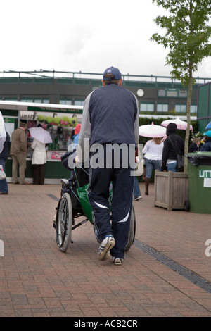 behinderte Personen im Rollstuhl geschoben in Wimbledon Tennis Championship UK Stockfoto