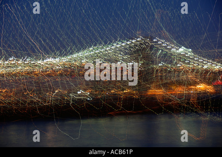 Eine vorsätzliche Verwacklungen erzeugt eine abstrakte impressionistische Wirkung auf s New Yorker Brooklyn Bridge bei Nacht Stockfoto