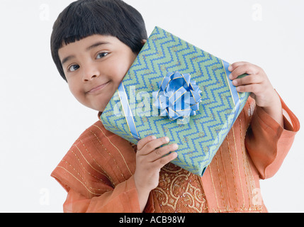 Porträt eines Mädchens trägt traditionelle Kleidung und hält ein Geschenk Stockfoto