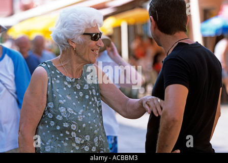 Frau im Sommerkleid glücklich im Gespräch mit Freund in Street, Venedig, Italien Stockfoto