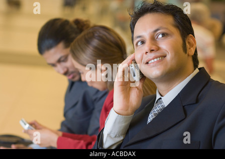 Nahaufnahme eines Geschäftsmannes, sprechen mit anderen Führungskräften neben ihm auf dem Handy Stockfoto
