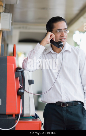 Mitte erwachsenen Mannes reden auf einer Telefonzelle Stockfoto