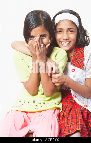 Porträt eines Mädchens mit ihren Arm um ein anderes Mädchen sitzend Stockfoto