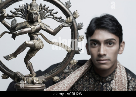 Porträt eines jungen Mannes mit der Nataraja Statue Stockfoto