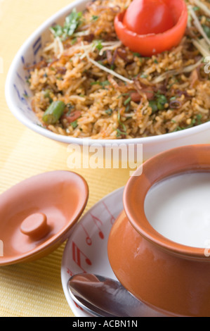 Nahaufnahme einer Schüssel gebratener Reis mit einer Schüssel Quark auf einen Teller Stockfoto