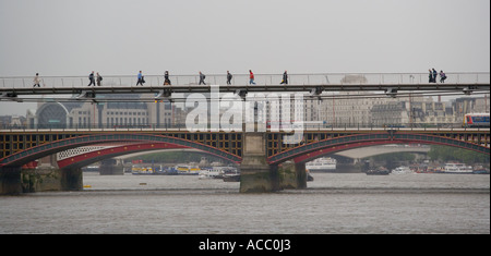 Fußgängerzone zu Fuß über die Millennium Bridge über die Themse in London England. Die berühmten Blackfriars Bridge im Heck Stockfoto