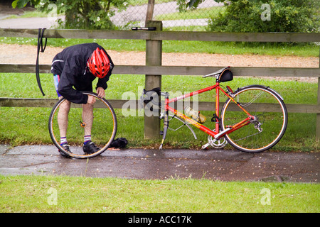 Radfahrer Reparatur Punktion auf Bürgersteig Stockfoto