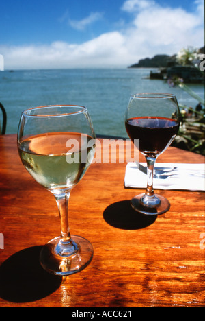 Gläser von roten und weißen Wein auf einem Holz Tisch in einem Restaurant im freien Stockfoto