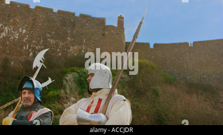 Zwei Männer, die als Gardisten aus dem 15. Jahrhundert verkleidet sind, stehen vor Mont Orgueil Castle, auch bekannt als Gorey Castle, auf der Insel Jersey. Stockfoto