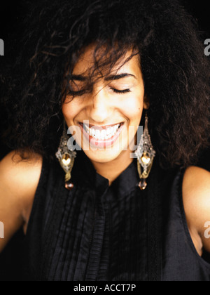 Frau trägt eine schwarze Bluse und große Ohrringe. Stockfoto