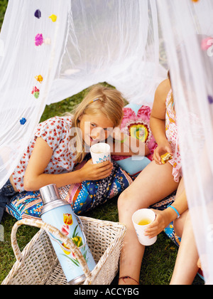 Zwei Mädchen haben einen Picknick unter einem Moskitonetz. Stockfoto