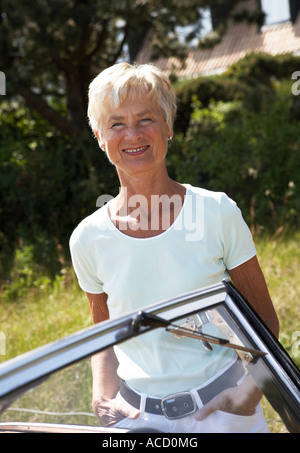 Eine Frau stand neben einem Cabrio. Stockfoto