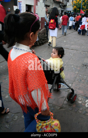 Straßenszene in Sucre, Bolivien. Junge Mädchen tragen Poncho und Baby im Push-chrair Stockfoto