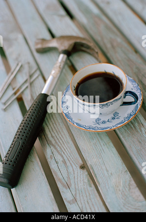 Ein Hammer und eine Tasse Kaffee. Stockfoto