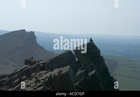 Einsamer Kletterer sitzt auf einem Hügel mit Henne Wolke im Hintergrund Stockfoto