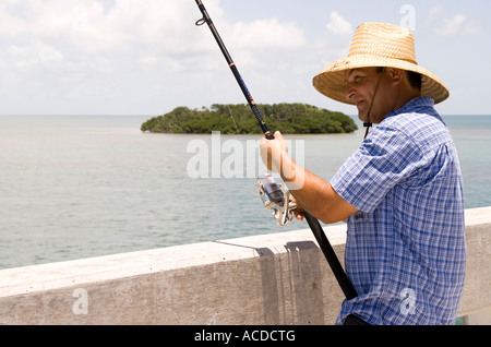 Hispanic man fischt von der Seven Mile Bridge in Little Duck Key in Florida Keys Stockfoto