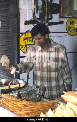 Ein Mann bereitet frische Jelabee, eine Art von süß, in Shimla Indien; Er drückt die rohe Mischung aus einer Glasur-Beutel in das heiße Öl Stockfoto