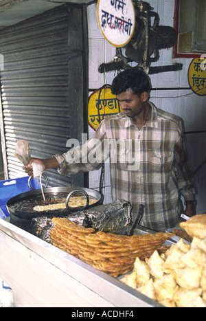 Ein Mann bereitet frische Jelabee, eine Art von süß, in Shimla Indien; Er drückt die rohe Mischung aus einer Glasur-Beutel in das heiße Öl Stockfoto