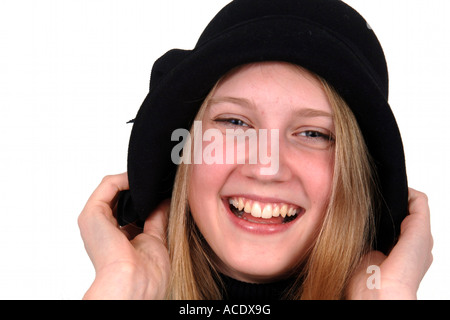 Foto eines lächelnden stilvollen Mädchens reißt ihre schwarzen Hut über ihre Ohren Stockfoto