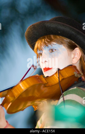 Musiker, gekleidet und machte sich als Clown auf der Bühne eine Geige zu spielen Stockfoto