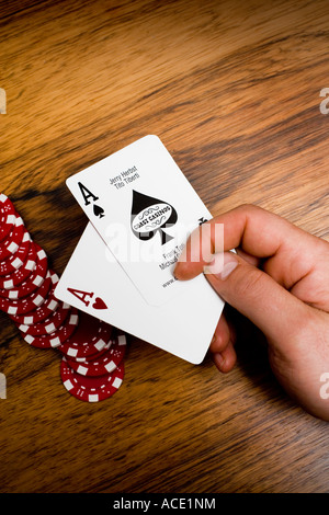 Eine Hand mit zwei Asse spielen Marken im Hintergrund. Close-up. Stockfoto