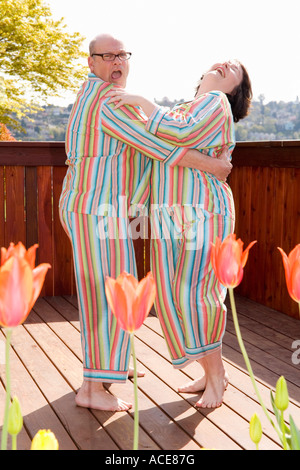 Paare tanzen auf Terrasse in passenden Pyjamas Stockfoto