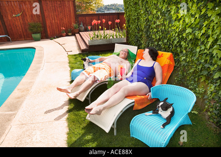 Paar auf Liegestühlen im Garten entspannen Stockfoto