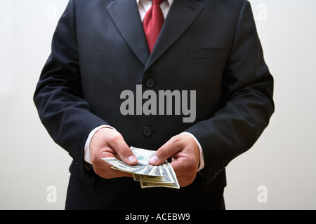 Geschäftsmann hält Stapel von 100-Dollar-Scheine Stockfoto